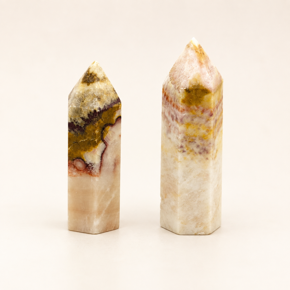 Two polished 10cm Pork Stone towers with cream, blush, mustard and burgundy natural banding