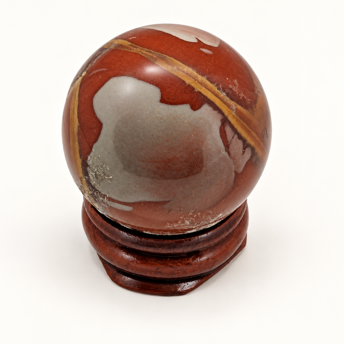 Polished Noreena Jasper sphere with red-brown, grey and mustard-yellow markings on a wooden display stand